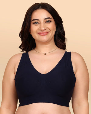 Woman wearing a black bralette against a beige background