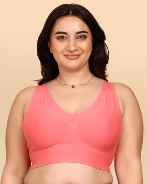 Woman wearing a pink bralette against a beige background
