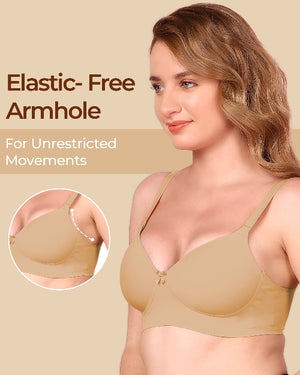 Woman wearing a beige bra with an elastic-free armhole feature, on a beige background.