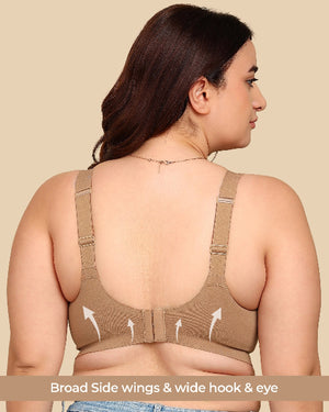 Woman wearing a beige sports bra with open back on a beige background