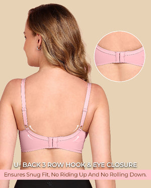 Woman wearing a pink bra with a close-up of the back closure on a beige background.