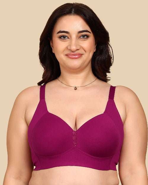 Woman wearing a purple bra against a beige background