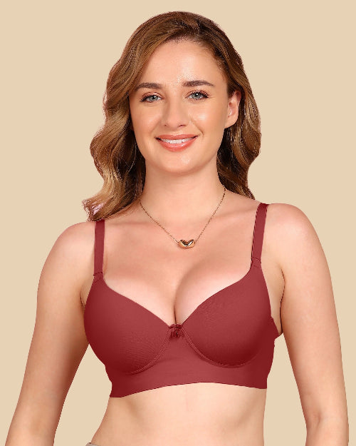 Woman wearing a maroon bra against a beige background