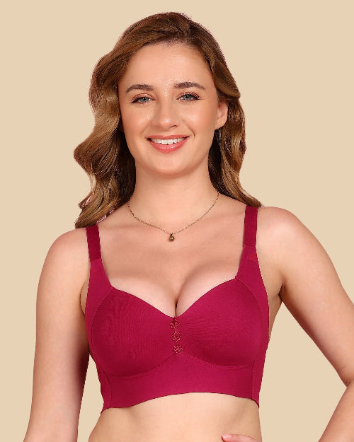 Woman wearing a maroon bra against a beige background
