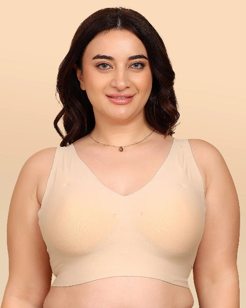 Woman wearing a beige tank top against a beige background