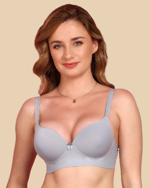Woman wearing a light gray bra against a beige background