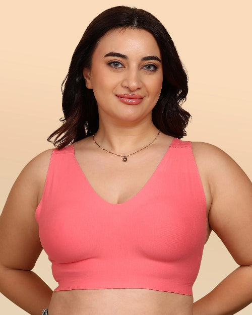 Woman wearing a pink sports bra against a beige background
