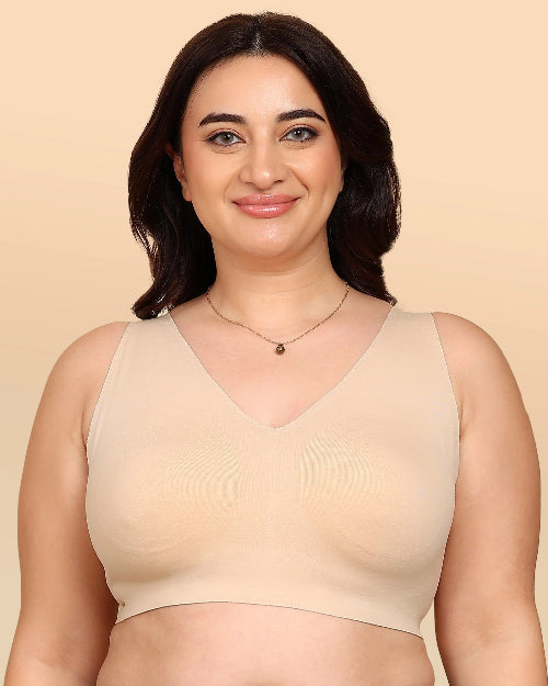 Woman wearing a beige tank top against a beige background