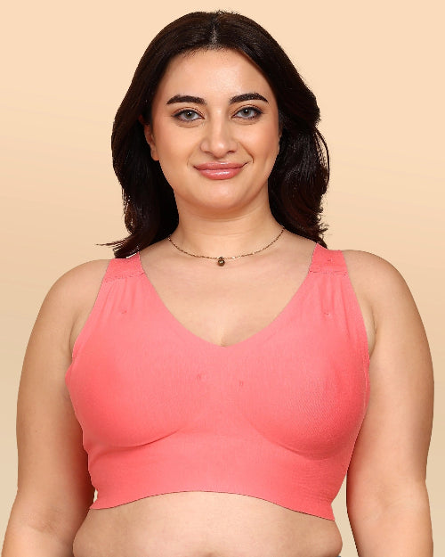 Woman wearing a pink bralette against a beige background