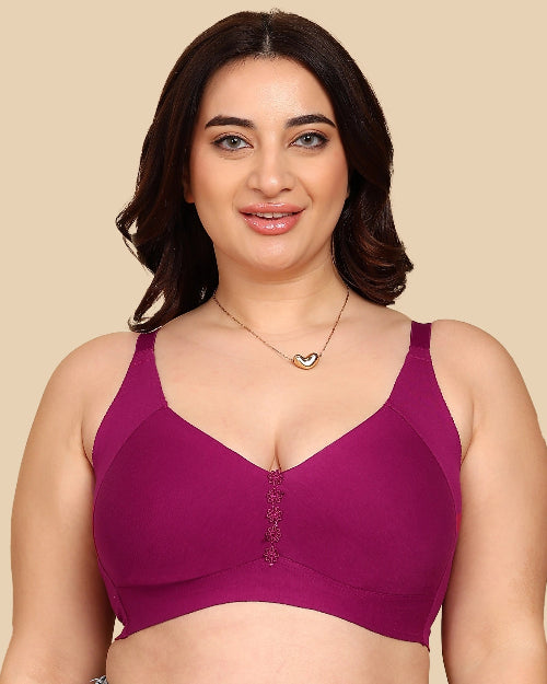 Woman wearing a purple bra against a beige background