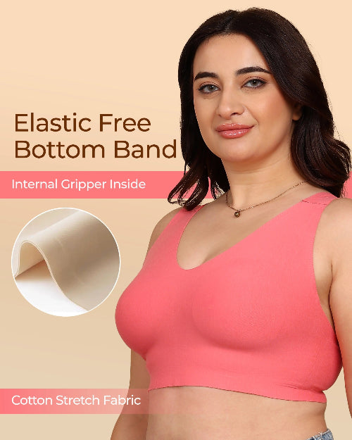Woman wearing a pink sports bra with text about an elastic free bottom band and cotton stretch fabric.