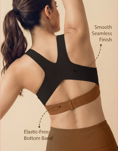 Woman wearing a black sports bra with brown bottom band, highlighting features on a beige background.