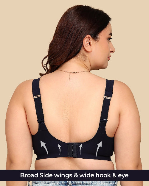 Woman wearing a black bra with wide hook and eye closure on a beige background