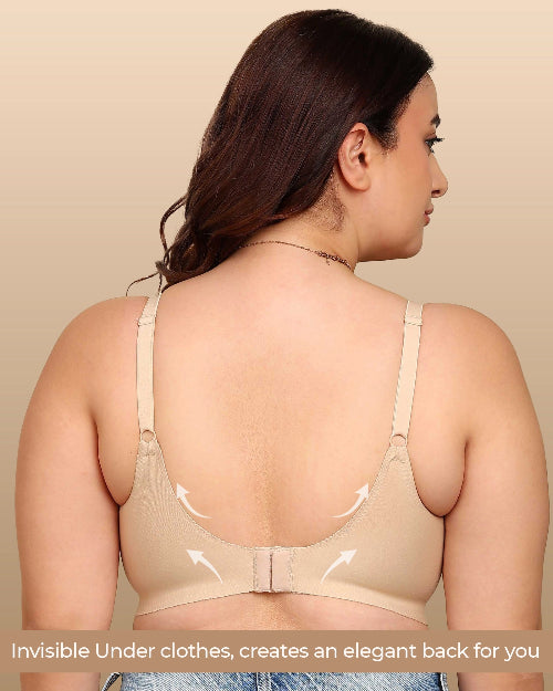 Woman wearing a beige bralette against a beige background