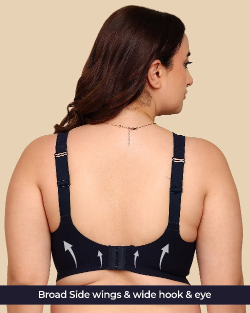 Woman wearing a black bra with wide hook and eye closure on a beige background