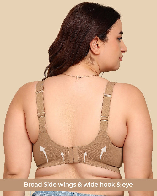 Woman wearing a beige sports bra with open back on a beige background