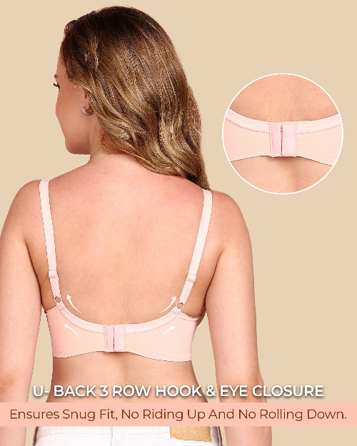 Woman wearing a pink bra with a close-up of the U-back closure on a beige background.