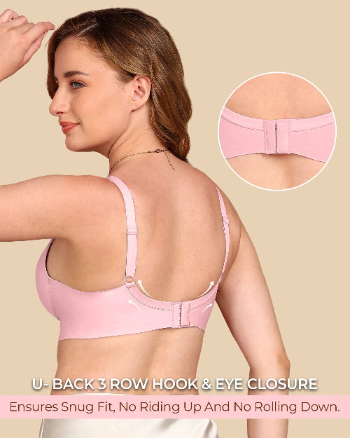 Woman wearing a pink bra with close-up of back closure on beige background