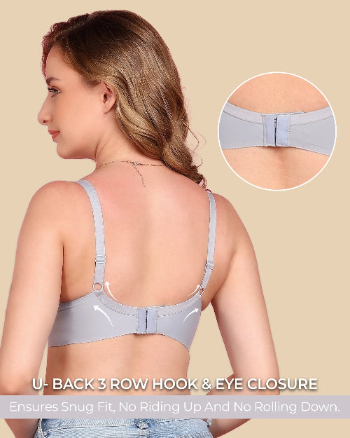 Woman wearing a light gray bra with a close-up of the back closure on a beige background.