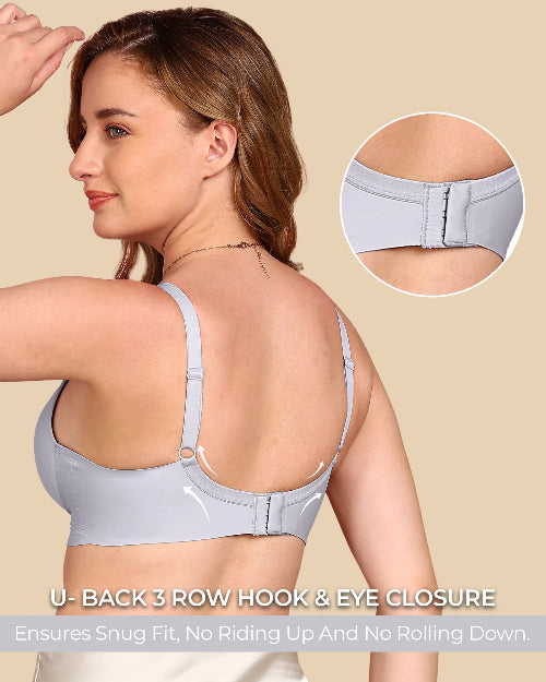 Woman wearing a light gray bra with close-up of back closure on beige background