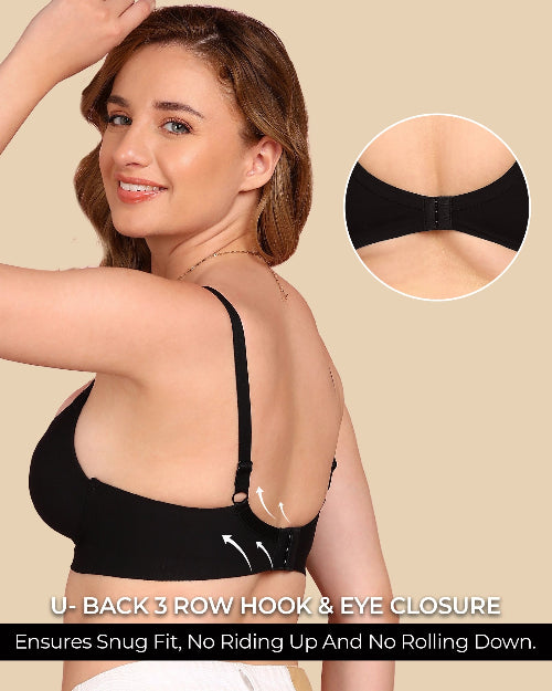 Woman wearing a black bra with a close-up of the closure mechanism on a beige background.